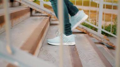 女腿体育运动运动鞋蓝色的牛仔裤走楼上户外女人脚体育运动鞋子攀爬楼梯地面穿越